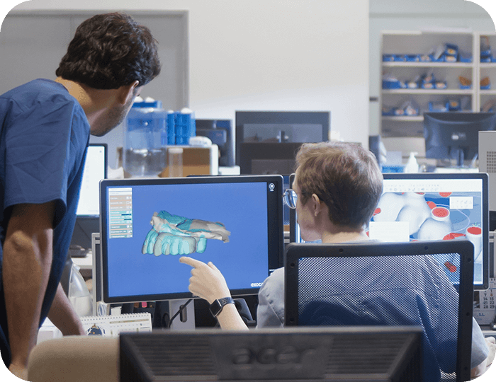 Dental lab technicians working together in a modern lab setting